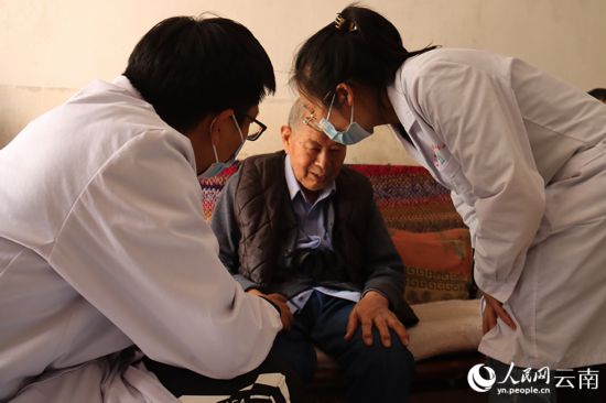 官渡区医养结合服务人员朱密朵和潘飞正在为张光林老人做健康监测和康复理疗。人民网 曾智慧摄